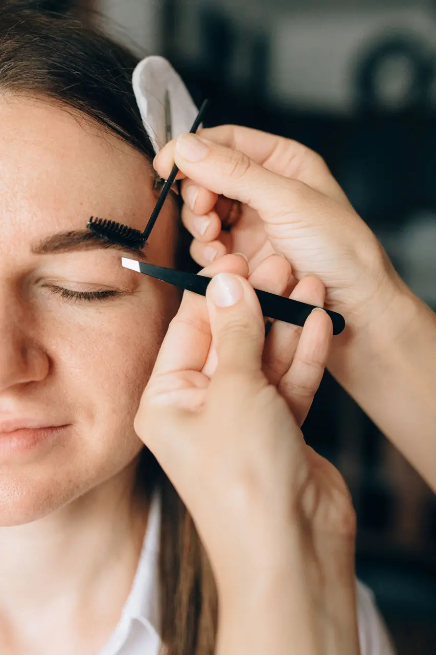 Brow artist shaping a client's eyebrows